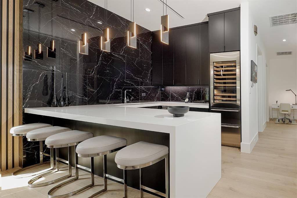Game room kitchen featuring Gaggenau microwave,Fisher & Paykel deep drawer dishwasher, garbage disposal, Sub-zero glass front wine storage & two drawer refrigerator.
