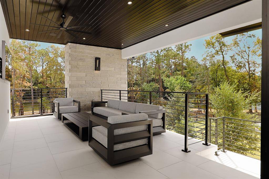 This is a spacious covered second floor veranda off the game room with serene views of Lake Woodlands and the pool area. The area is well-protected from the elements, featuring a ceiling fan for additional comfort.  Stairway leading to the pool veranda.