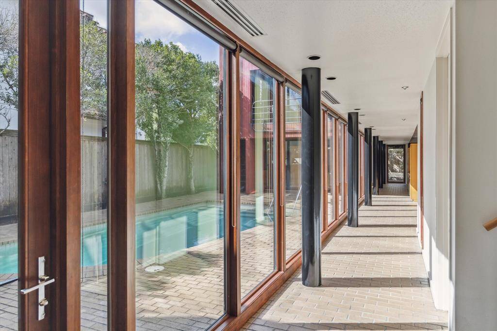 The walkway to the living areas of the home.  Recent Pella windows throughout the home. Commercial AC ducts were original to the home. All windows have adjustable black shades.