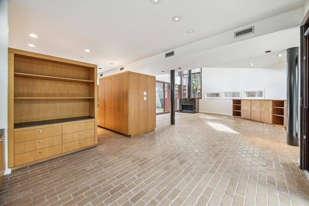 The dining room , kitchen and living room. There  is a wood burning, free standing fireplace with a black polechimney.
