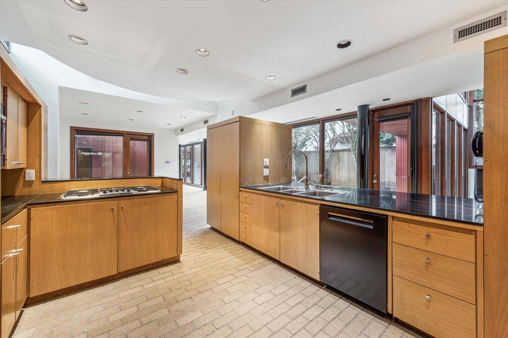 The kitchen which is open to serving all three downstairs rooms.  Black granite countertops and black appliances.The dishwasher and the icemaker which is on the bar side of the counter were replaced (10/24).