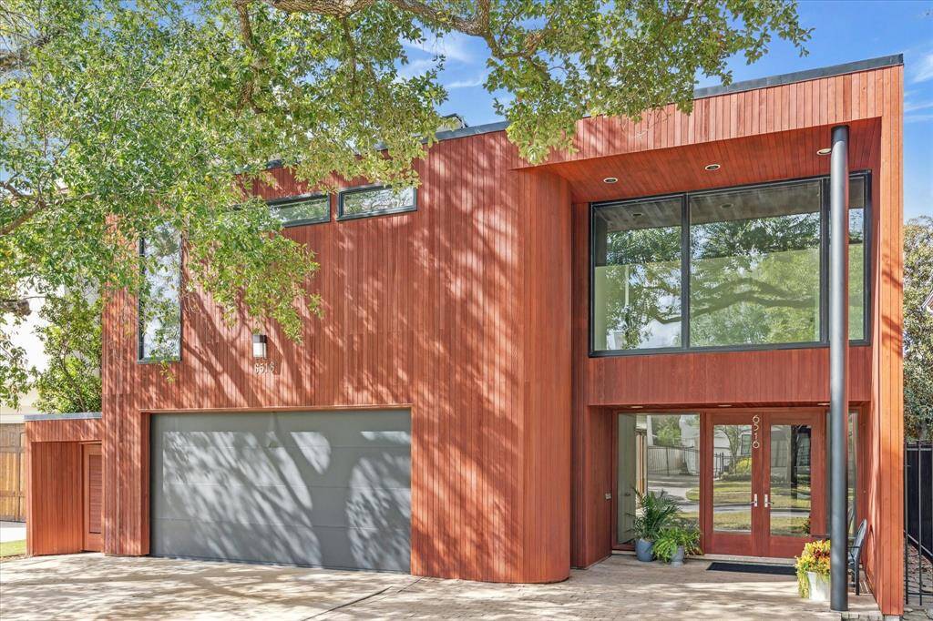 The cedar siding and the walls of windows and black poles continue throughout the home for its unique architectural design.