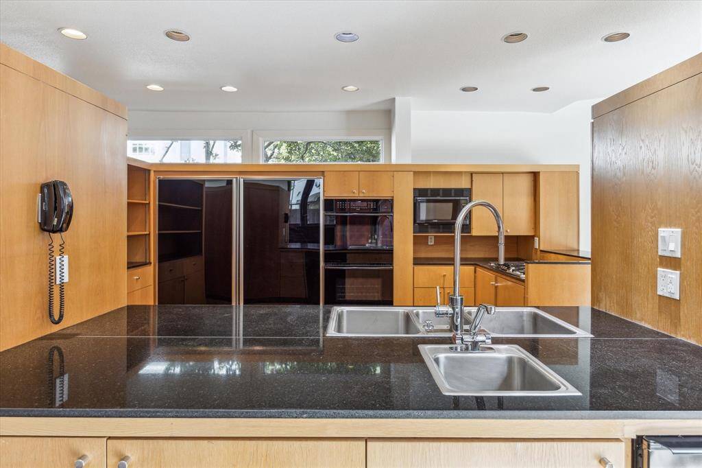 Large double refrigerator/freezer,  double ovens, microwave, and bar sink complete the kitchen.  The black wall phone is still there for nostalgia's sake.