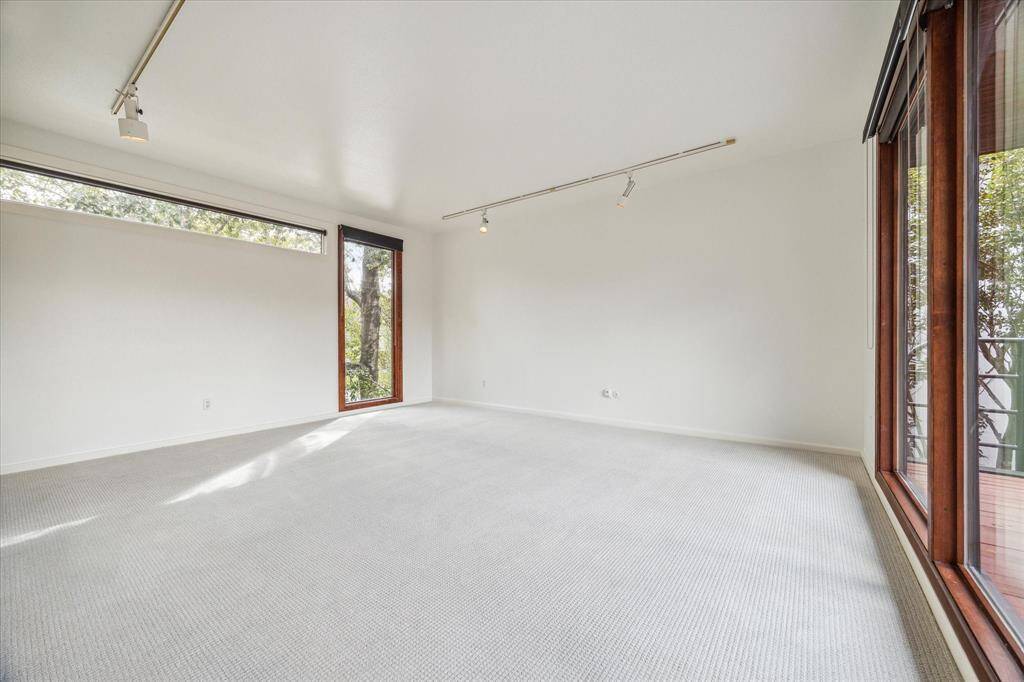 One of the second floor secondary bedrooms which overlooks the pool from its private balcony.