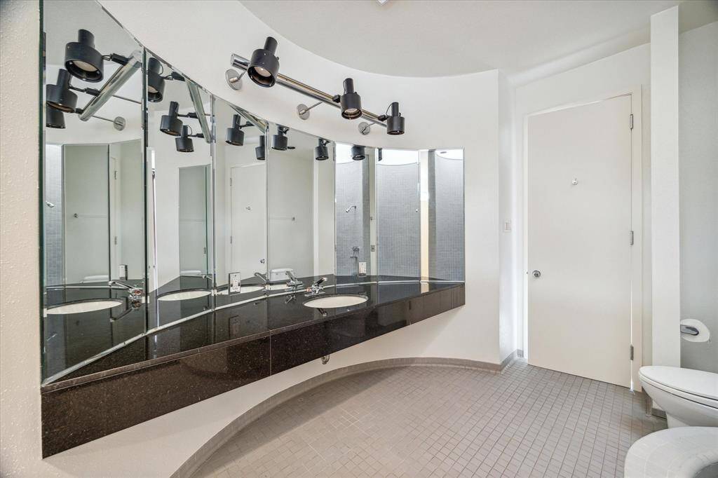 One of the two primary bathrooms. Black granite counter tops, tile floors and a circular shower/tub.
