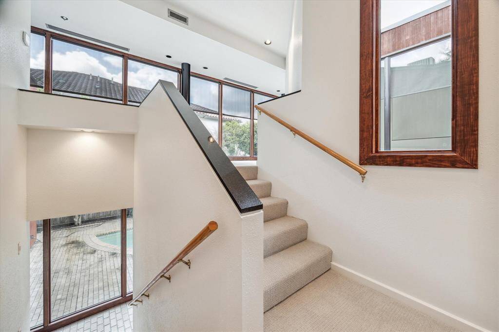 The staircase  to the second floor with black marble accents on the side railing. New carpeting (10/24) extends throughout the second floor.