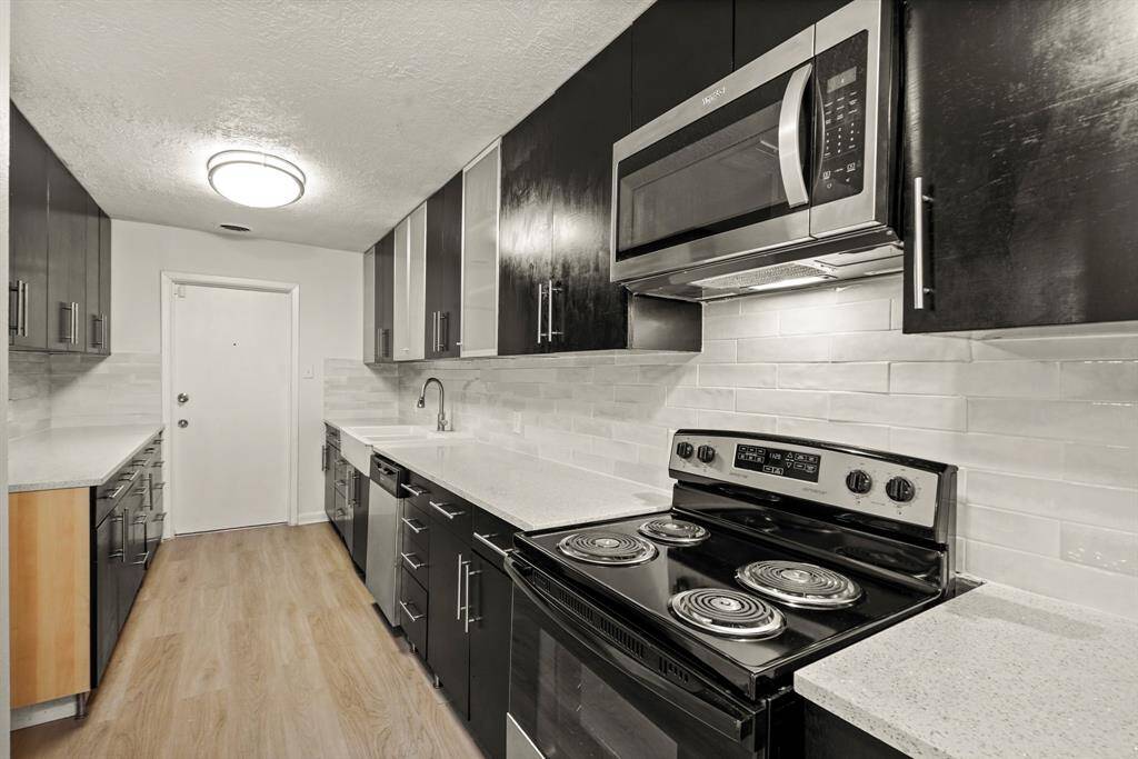 Now into your kitchen. Features include granite countertops paired with a coordinating tile backsplash, high end appliances, and richly painted cabinets with updated hardware.