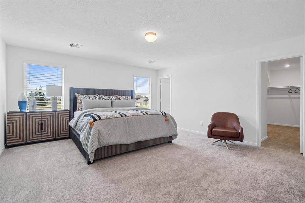 What a wonderful place to come home to, this stunning primary suite greets you with gorgeous plush carpet, custom paint, high ceiling, lighting, and lovely windows allowing in natural light brightening up this spacious primary bedroom!