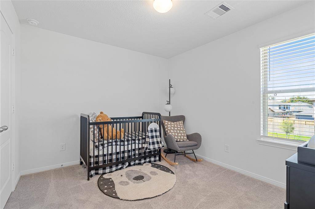 Secondary bedroom features plush carpet, neutral paint, lighting, large window, and ample sized closet space.