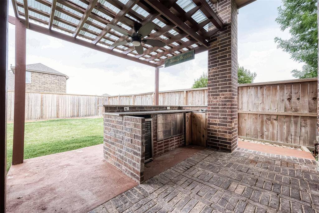 Enjoy the inviting outdoor bar and kitchen just off the patio, perfect for entertaining. The fence has been updated for added privacy.