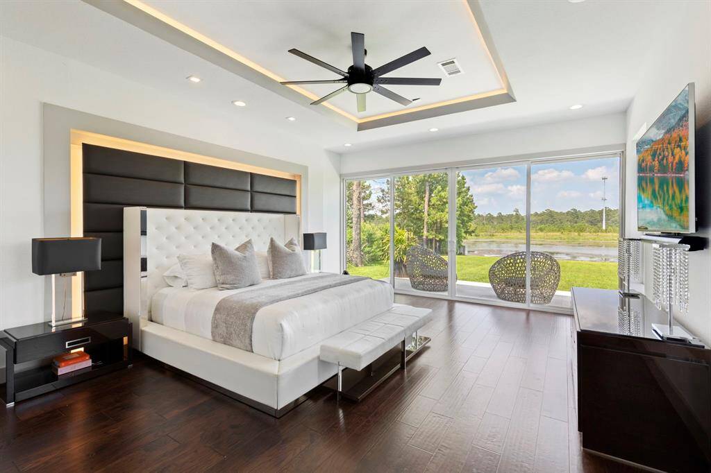 A sleek and serene primary suite is spacious and inviting. Taking in exceptional views with sliding doors that open to a private patio. Warm engineered wood floors compliment the space.
