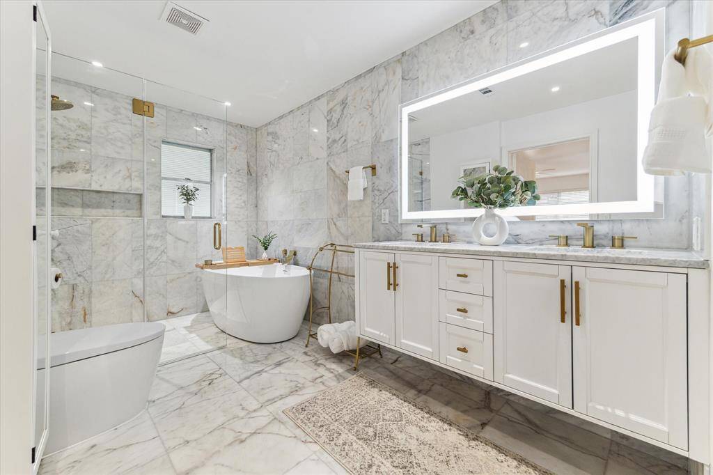 Primary bathroom fully remodeled in 2021, walk in shower with marble tile, linear shower drain, large tub, double sink bathroom vanity with marble top, LED bathroom mirror with anti fog, dimming and waterproof features
