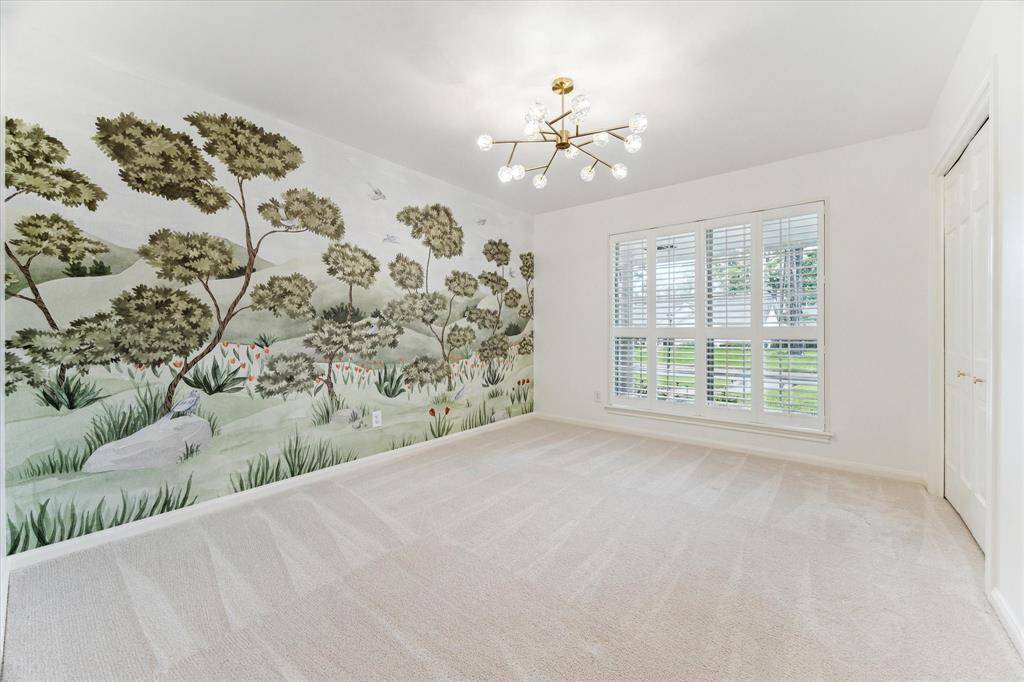3rd bedroom with dimmable light fixture, custom wall mural, built in closet system and wood shutters