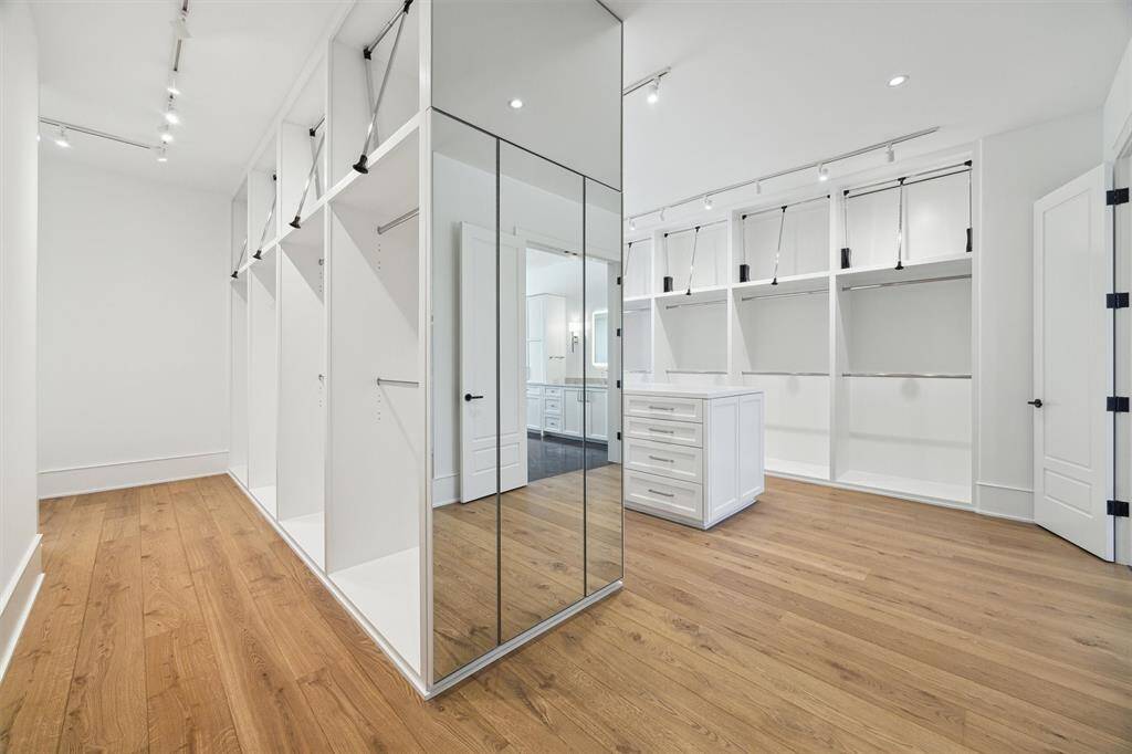 His and Her closets separated by a full length 3 way mirror