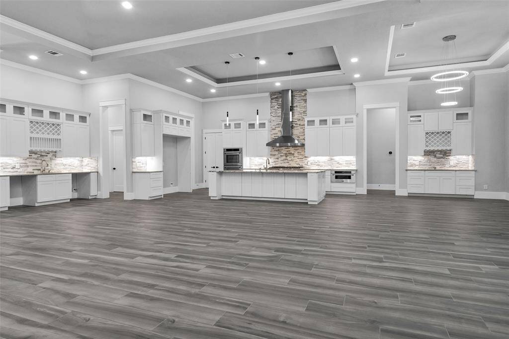 Open-concept Kitchen features a large island w/ a Breakfast Bar for casual family dining, along with a more formal Dining Space conveniently located just steps away.