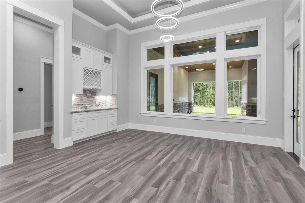 This beautiful Dining Room sparkles under beautiful circular tiered chandeliers, offers a convenient sideboard with storage and opens to the outdoor space for ease of indoor/outdoor living.