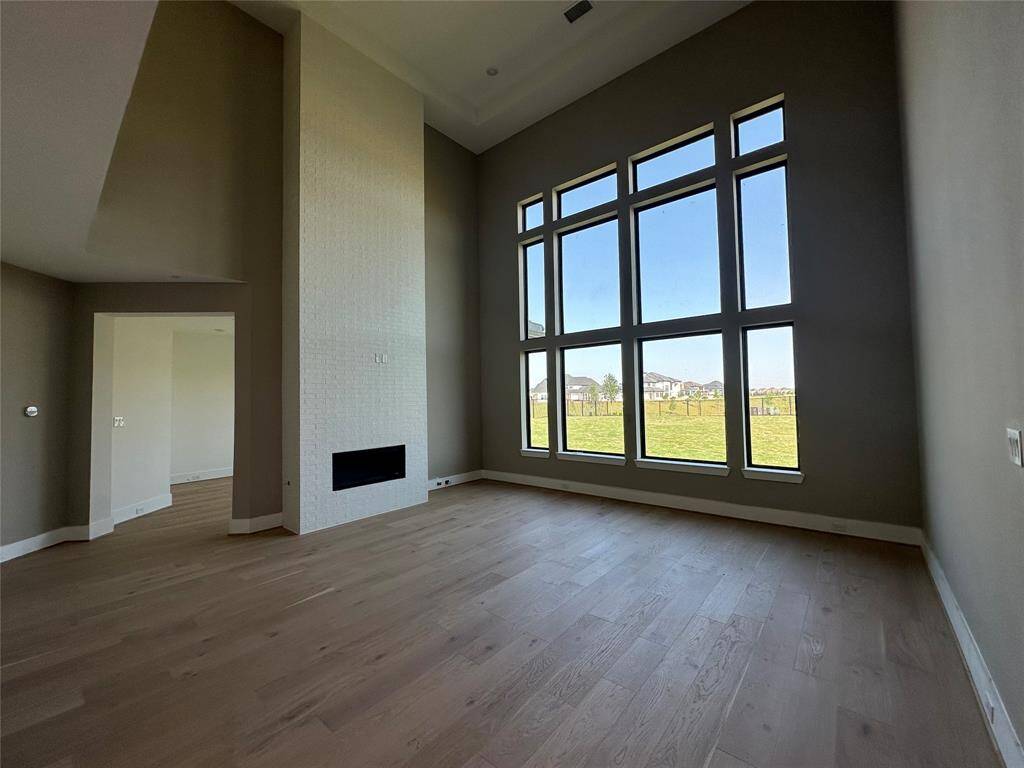 View from elevated 2-story Living Room towards the front of the home with grandiose Foyer with winding staircase and Butler's Pantry off of Formal Dining Room and Kitchen.