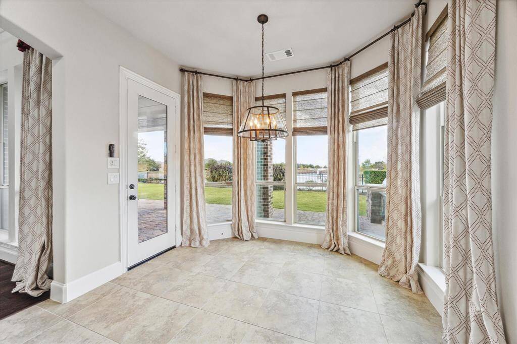 The cheery breakfast room has a bay shape with windows overlooking the lake and yard. It is large enough for a table that seats 6 comfortably. Your back patio is accessed through the door shown.
