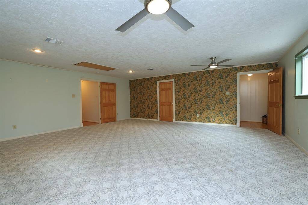 View from the other side of the Master suite looking towards the back stair case with chair lift on the right, walk-in closet in the middle, and door to the hall with secondary bedrooms on the left.