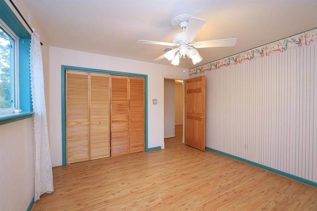 This secondary bedroom measures approx 12x12 and includes a deep reach-in closet, laminate flooring, double pane windows, and a ceiling fan with lights.