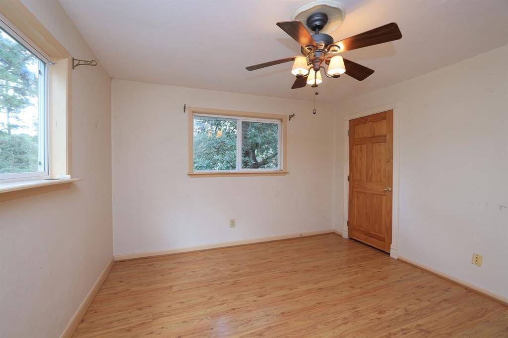 This secondary bedroom measures approx 12x12 and includes a walk-in closet, 2 large double pane windows, laminate flooring, and a ceiling fan with lights