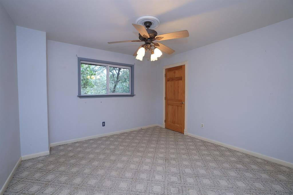 This secondary bedroom measures approx 12x12 and features a walk-n closet, large double pane window, carpeting, and a ceiling fan with lights