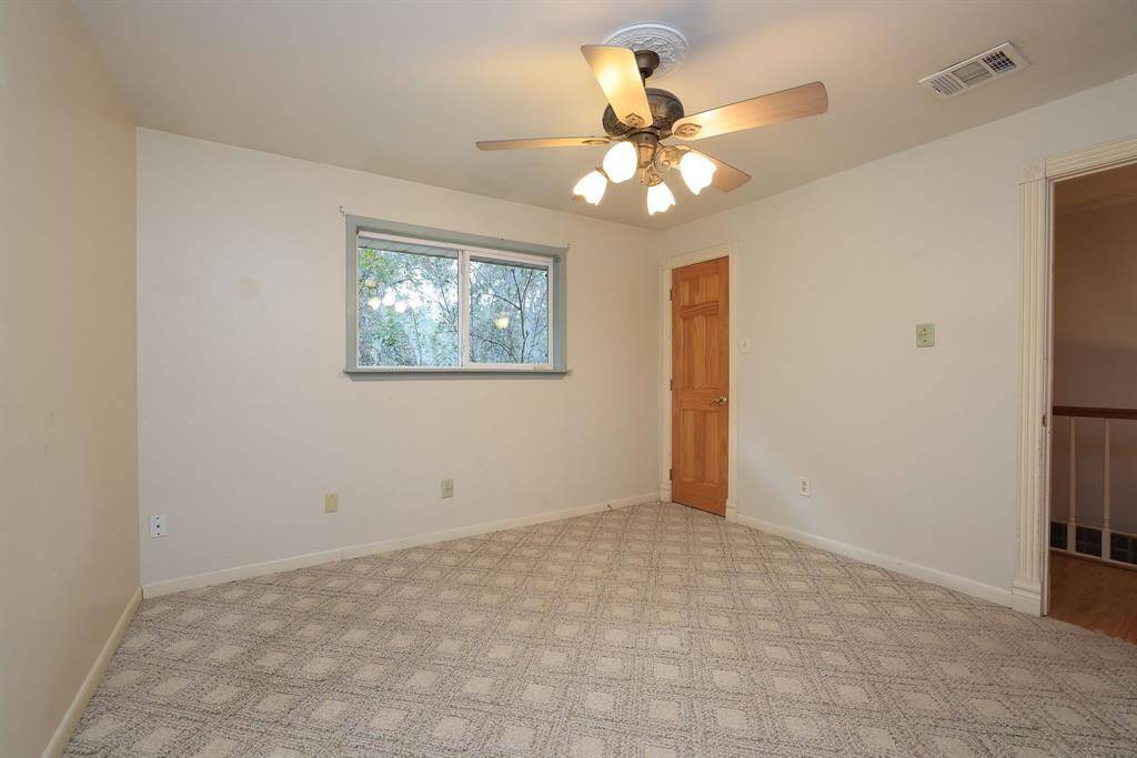 This secondary bedroom measures approx 12x12 and features a walk-n closet, large double pane window, carpeting, and a ceiling fan with lights.