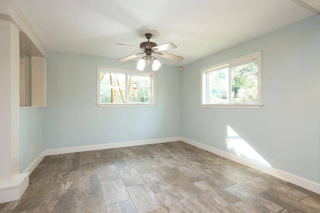 The family room includes large, double pane windows for added light and energy efficiency, ceiling fan with lights, and easy to keep clean wood-look tile floors.