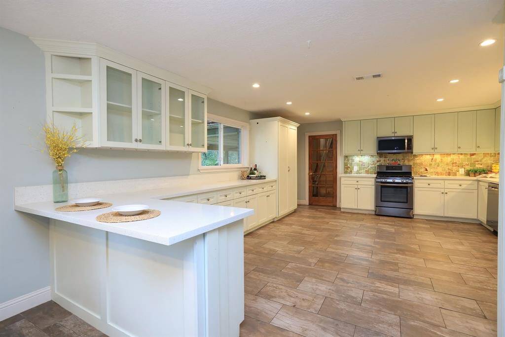 Nothing says home like the Kitchen! The chef in your family will fall in love with this beautifully updated and oversized kitchen. Gas Cooking, Quartz counters, custom marble tile backsplash, S/S appliances, single basin Farm House sink and TONS of storage!