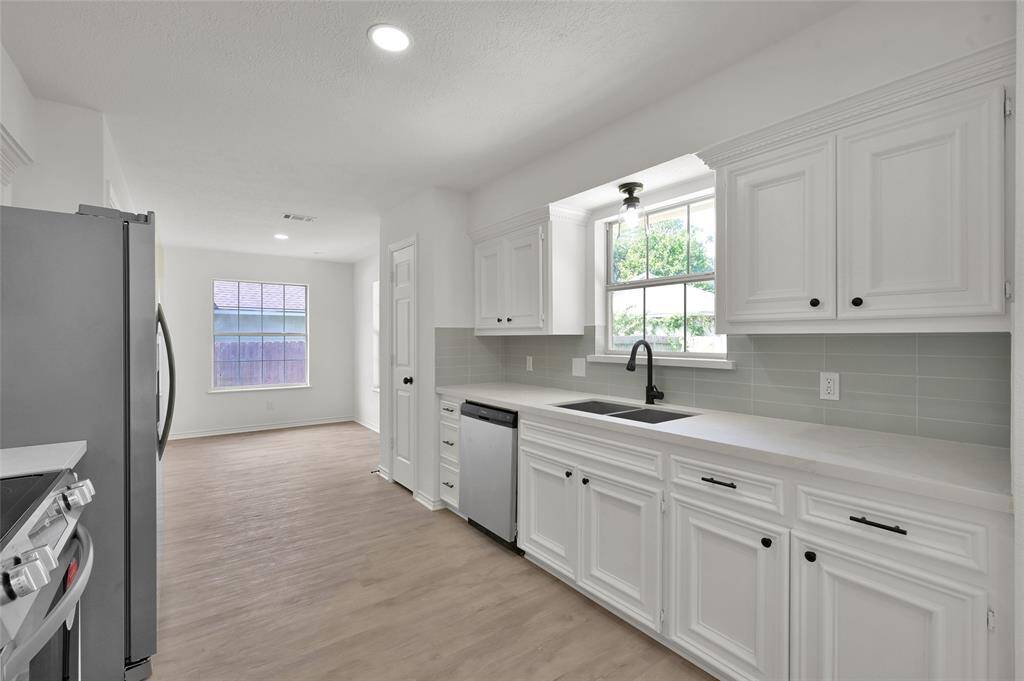 The modern kitchen boasts brand new stainless steel appliances, new quartz countertops, gorgeous new backsplash, efficient new LED lighting, glistening new sink and faucets and all new cabinetry hardware!
