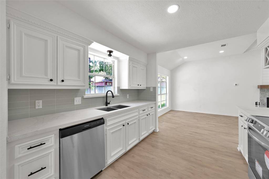 This freshly updated kitchen also boasts a gleaming stainless steel sink with new faucets and hardware with a beautiful view to the peaceful back lawn!