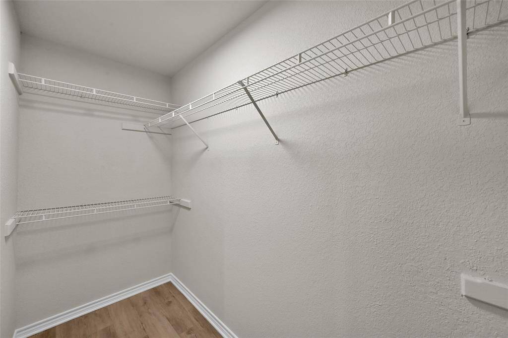 The adjacent walk-in closet is a dream, offering ample storage space with shelving to keep your wardrobe organized and easily accessible.