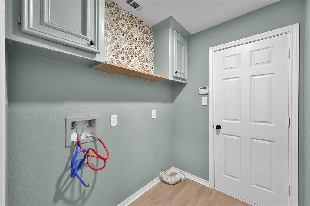 The room is graced with solid wood cabinetry, finished with crown moulding, offering both ample storage and a touch of sophistication.