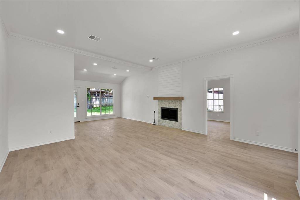 This open floorplan features high ceilings with crown moulding, new luxury vinyl plank flooring throughout, new LED lighting, and new fireplace surround!