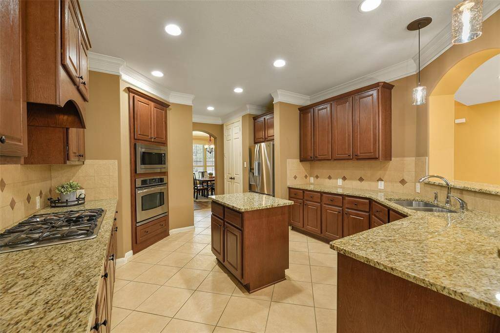 The chef of the house will appreciate the roomy double-door pantry located between the kitchen and the dining room. Also note the all stainless appliances that include a gas cooktop, a single electric oven, a built-in microwave, and a dishwasher.