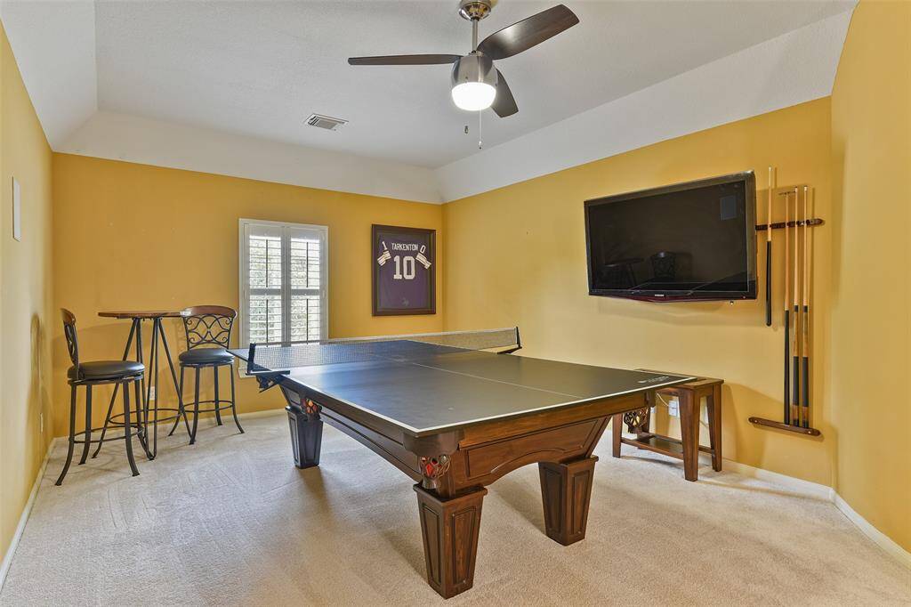 This home boasts an abundance of entertaining space, including this second-floor game room that is located at the top of the staircase. Here, you'll find a 9-foot gambrel ceiling with a lighted fan, plush new carpet, and a window with plantation shutters.