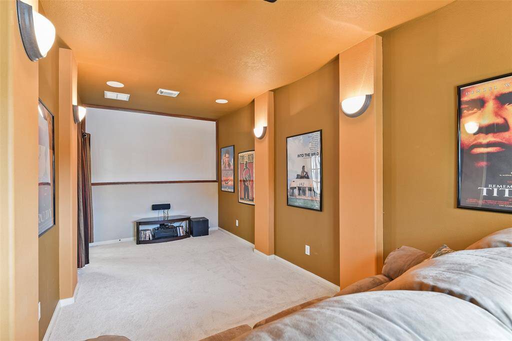 Yet another bonus space in this home is this dedicated media room, complete with dimmable sconce lighting, surround sound speakers, and plush new carpet with a custom-built step-up seating space.