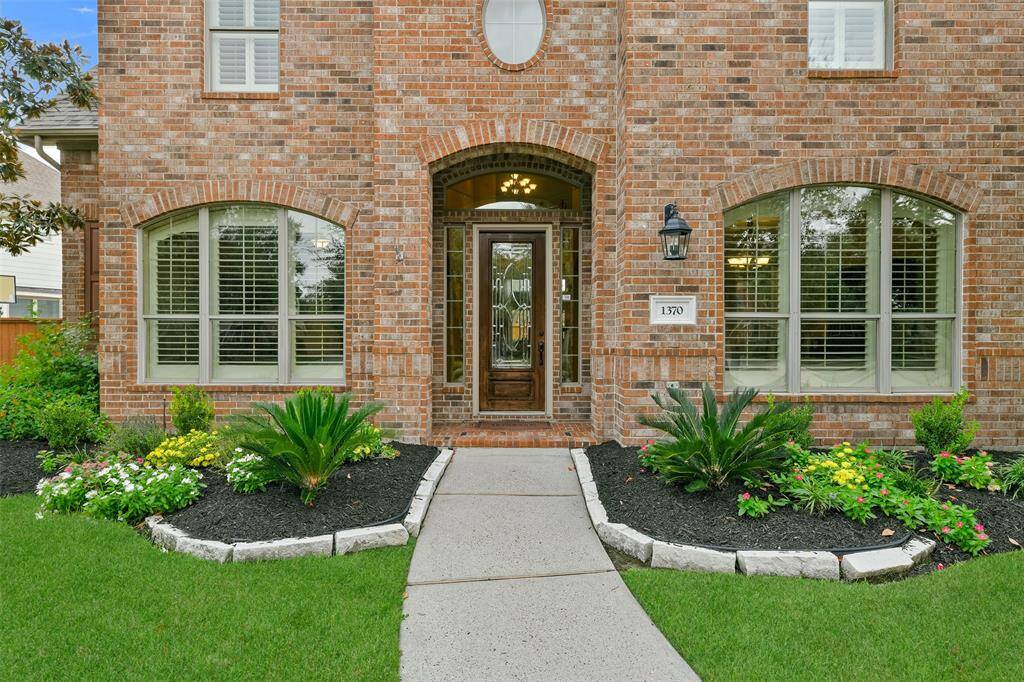 Fast-maturing oak and magnolia trees surrounded by freshly mulched landscape beds frame the front entrance of this 2006-constructed brick home that also offers ample parking with 3 garage spaces as well as a port cochere.