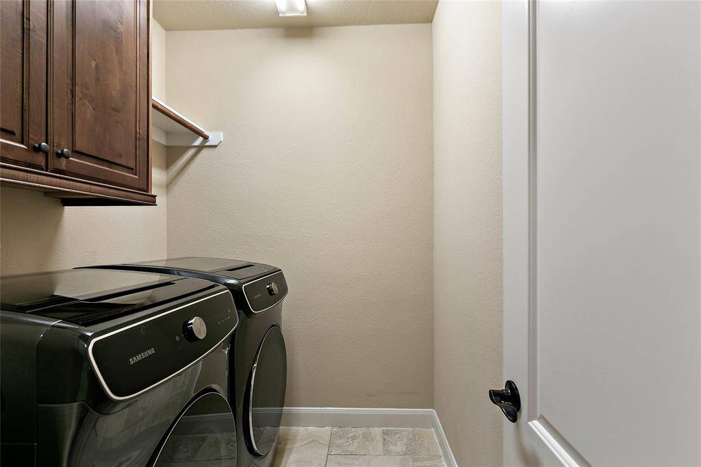 Spacious laundry room with cabinetry and hanging bar.