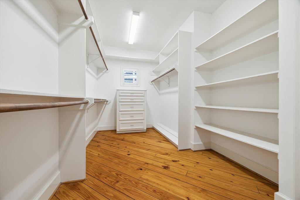 This spacious walk-in closet is directly off of the loft-style bedroom on the 3rd floor. The walls are lined with shelves and racks.