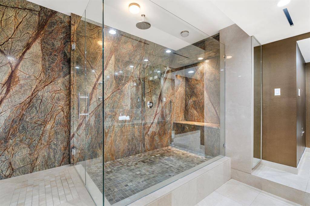 Large shower with bench and hidden recessed shelving.