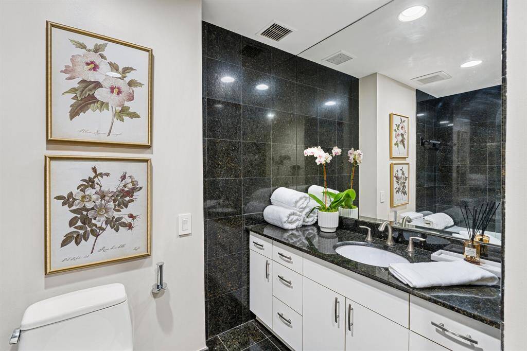 Guest bathroom with granite floors, counter tops and tub/shower surround.