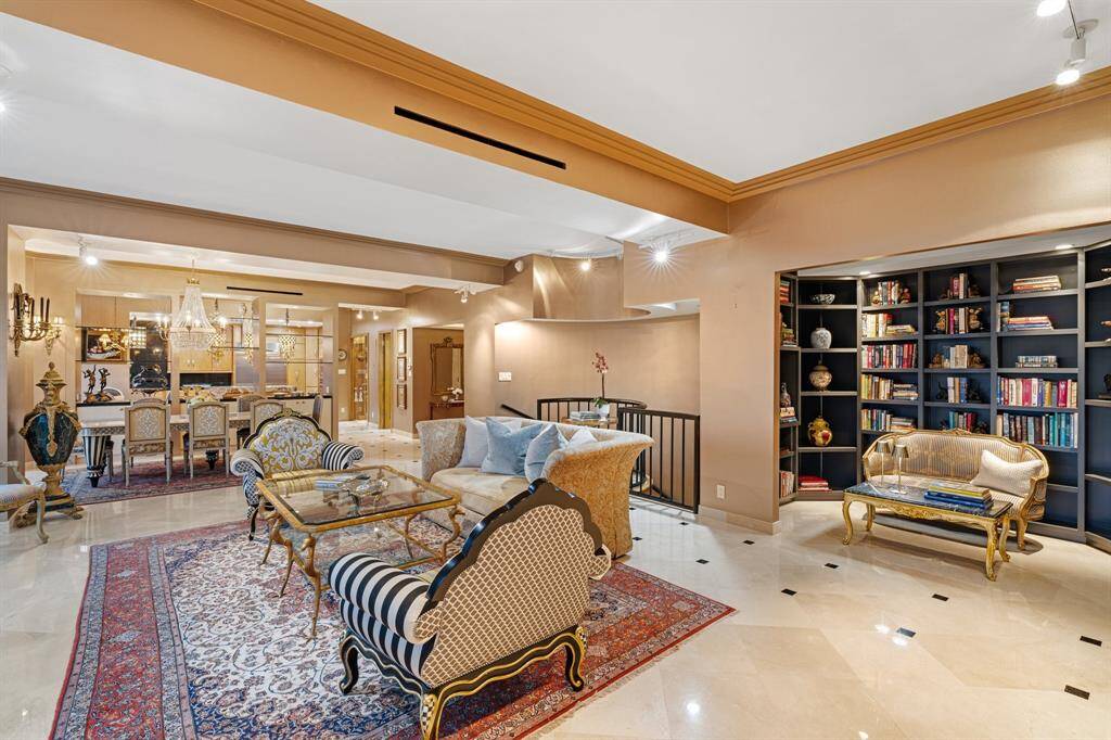 Living room with views of the library alcove, staircase and entry.