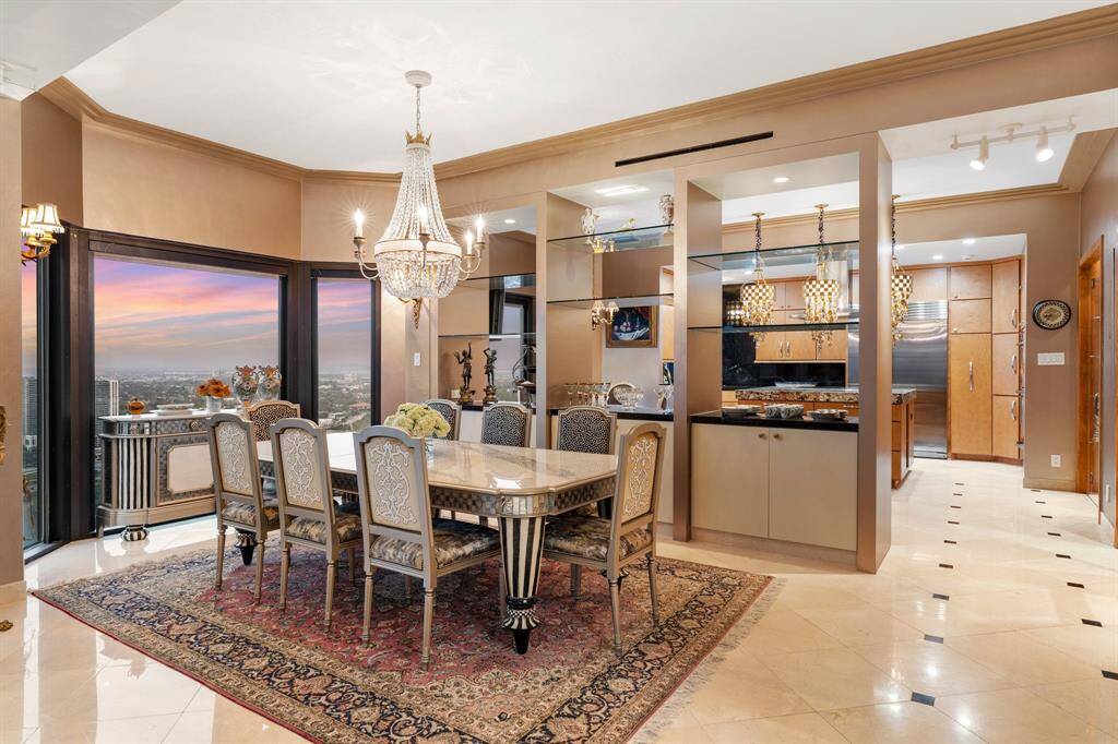Formal dining room with  open glass display shelving, granite buffet and shelved cabinetry below.