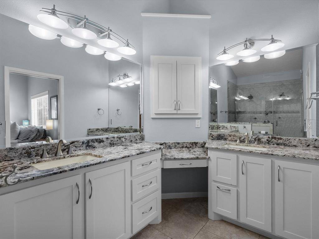 This Dual-Sink vanity Offers Ample Storage  and Bright Lighting Fixtures. The color Scheme is Neutral, Creating a Serene and Inviting Atmosphere.
