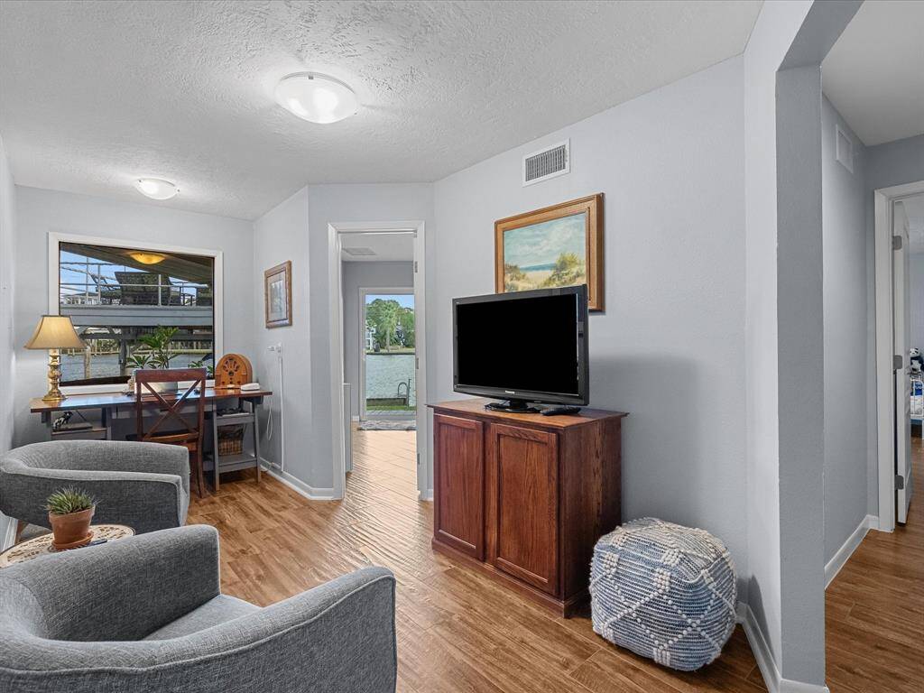 This Cozy, Well-Lit Space Features a Comfortable Seating Area and Office Space, Looking out onto Scenic Water Views.
