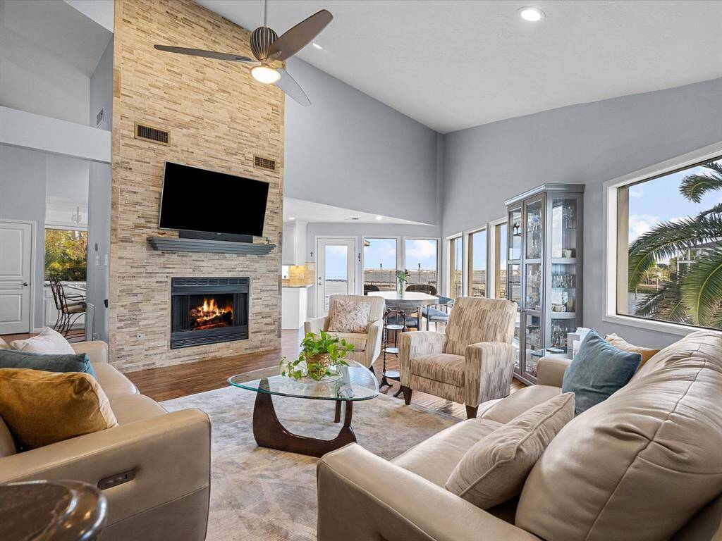 Spacious Living Room with Tall Open Ceilings and Modern Gas Fireplace that Brings Warmth into the Room. Perfect for Relaxing or Entertaining