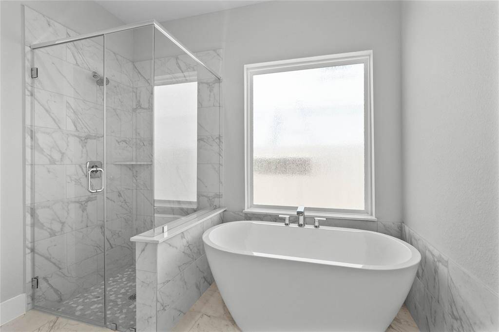Additional view of the primary bath showcasing the walk-in shower with tile surround and separate garden tub perfect for soaking after a long day.