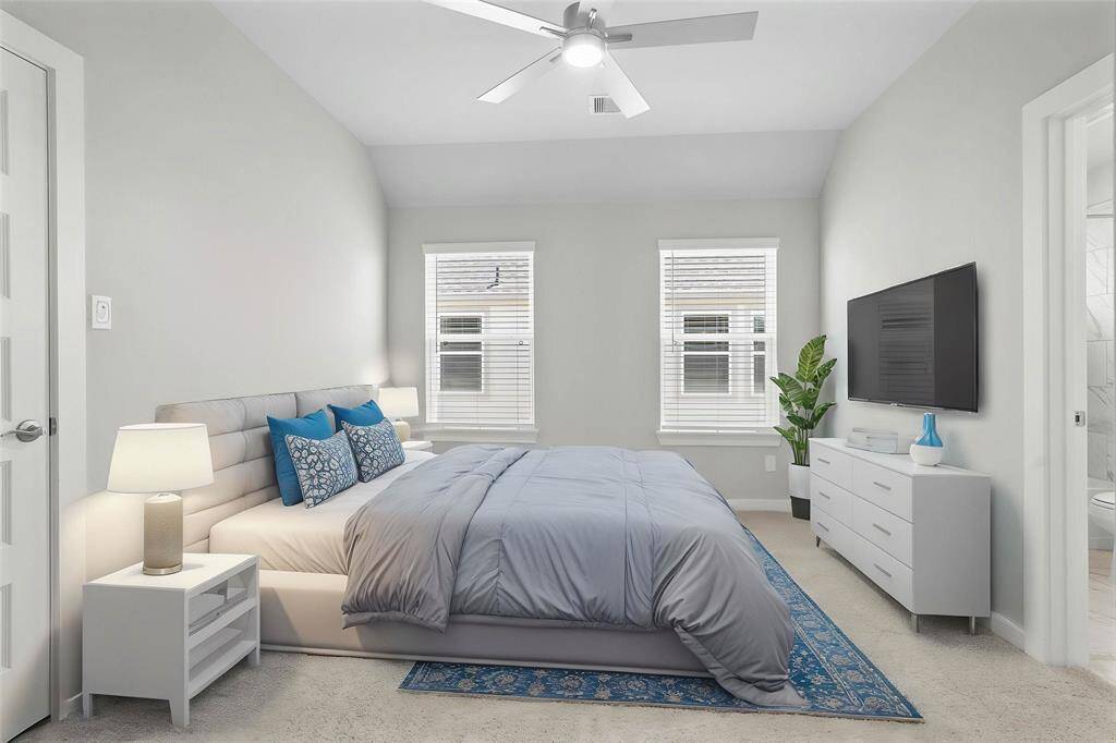 Secondary bedroom features plush carpet, custom paint, high ceiling with ceiling fan, large windows with privacy blinds, ample closet space, and private access to a secondary bathroom.