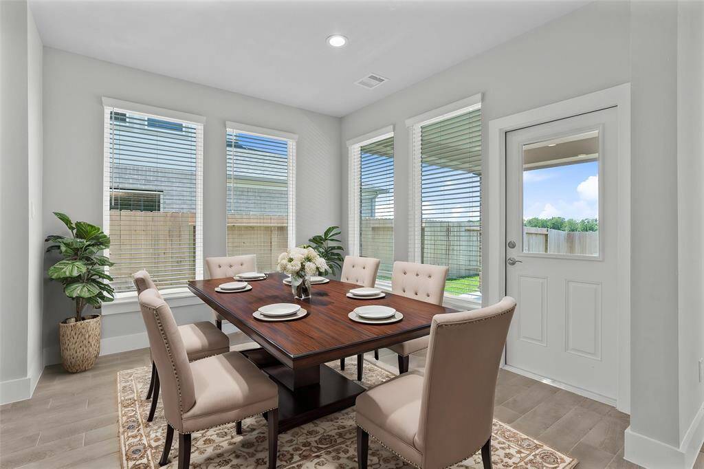 Make memories gathered around the table with your family and friends! This dining room features high ceilings, recessed lighting, large windows with blinds, access to the backyard, and beautiful wood look tile flooring!